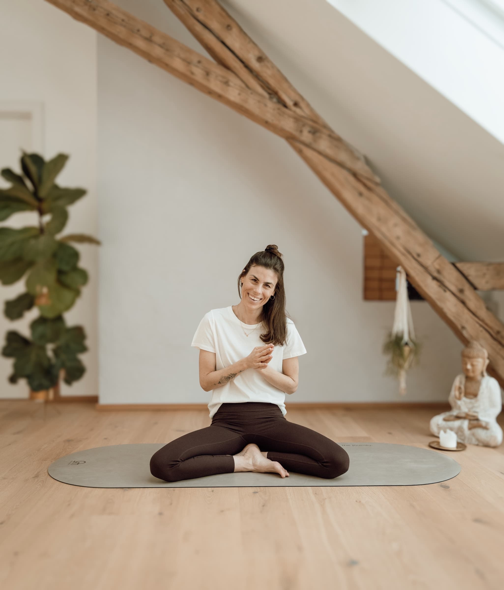 Lisa lachend auf der Matte im Studio mit Buddha-Figur